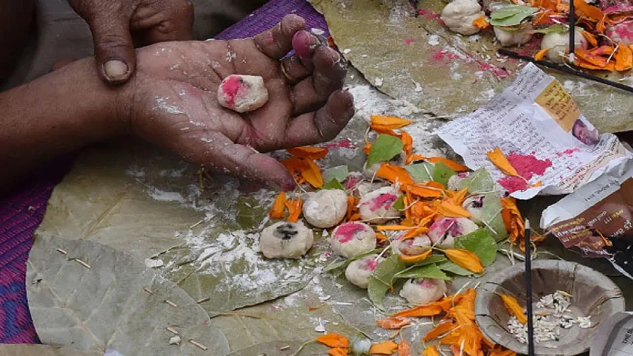 Pind Daan ritual during Narayan Nagbali Puja at Trimbakeshwar The pandit is holding pinda with sindoor and sesame and flowers and Sankalpa.