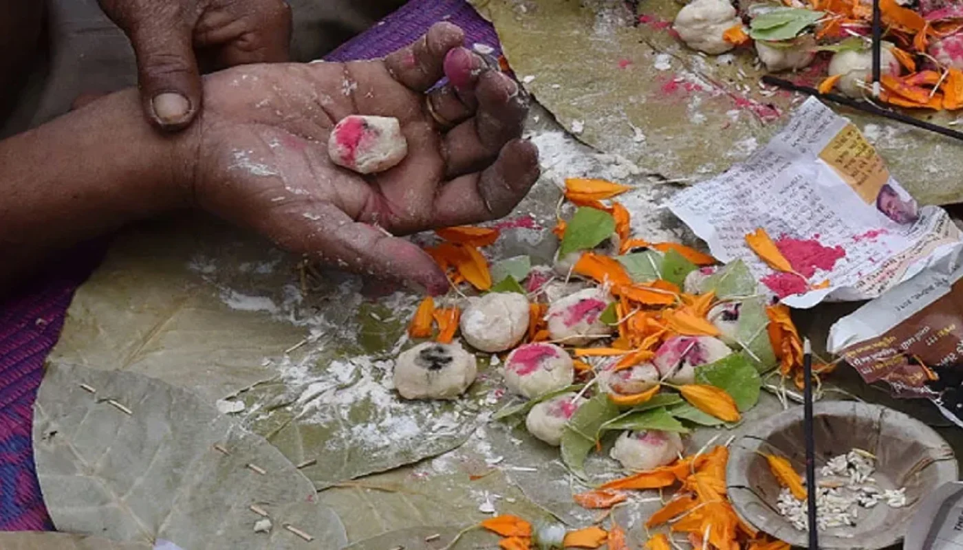 Pind Daan ritual during Narayan Nagbali Puja at Trimbakeshwar The pandit is holding pinda with sindoor and sesame and flowers and Sankalpa.